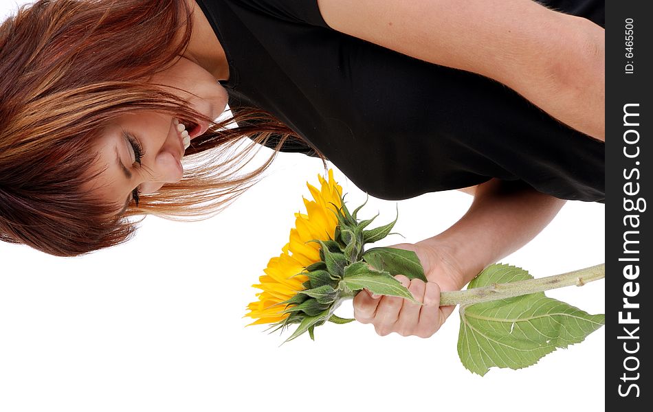Young attractive woman is smiling to the sunflower. Studio shot on white background.