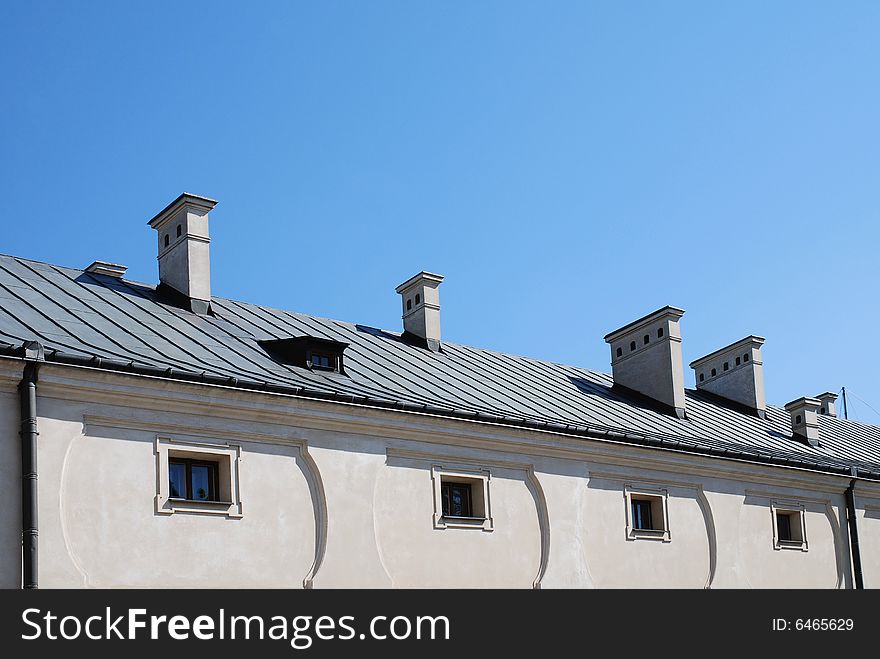 Old roof. chimney on the blue sky