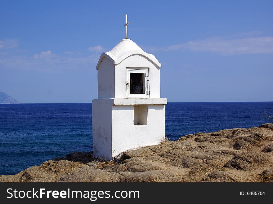 A white shrine in Sarti Beach overlooking the sea.