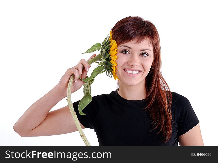 Young attractive woman is listening to the sunflower. Studio shot on white background.