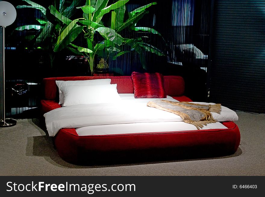 A red bed with white bedsheet. A red bed with white bedsheet...