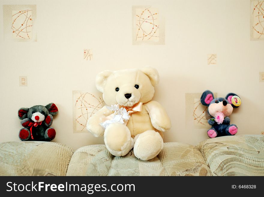 Three toy animals: one white bear and two mice are sitting next to a wall. Three toy animals: one white bear and two mice are sitting next to a wall