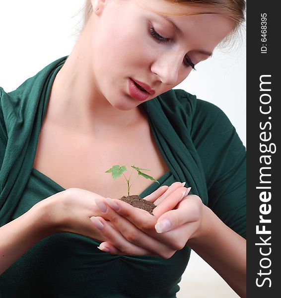 Beautiful young woman with green sprout of tree in her palms. Beautiful young woman with green sprout of tree in her palms