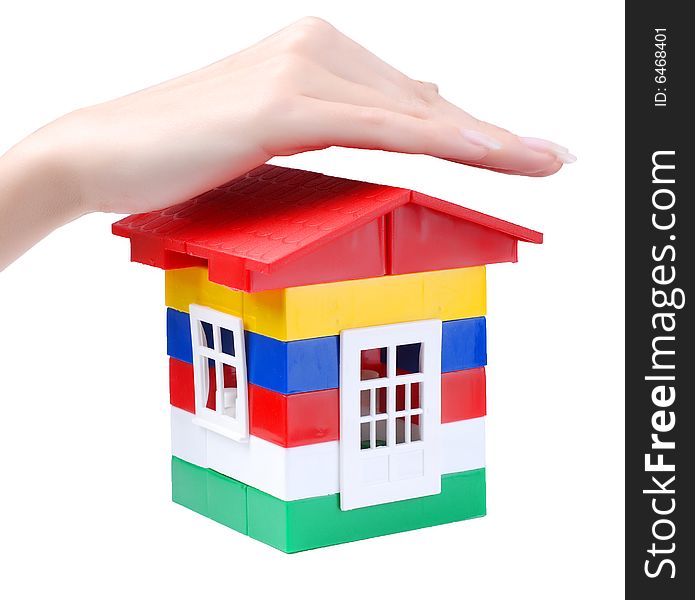Hand of young woman protect toy colour plastic house with red roof. Hand of young woman protect toy colour plastic house with red roof