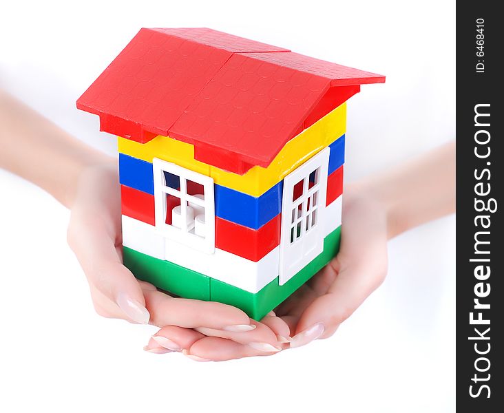 Toy colour plastic house with red roof in palms of young woman. Toy colour plastic house with red roof in palms of young woman