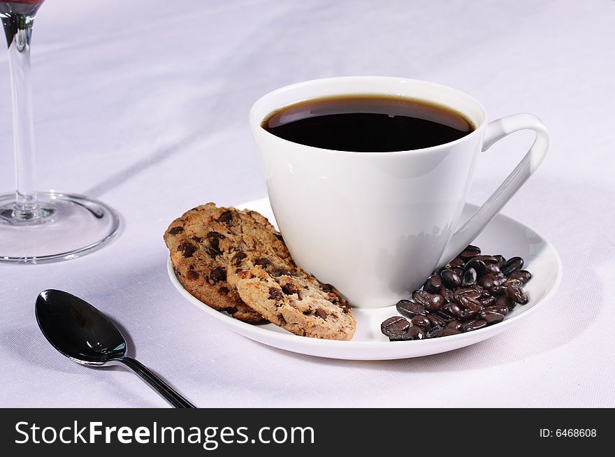 Coffee cup in a restaurant setting with biscuits and Coffee beans. Coffee cup in a restaurant setting with biscuits and Coffee beans