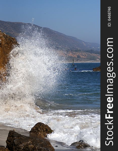 Wave splashing into a rock on malibu beach