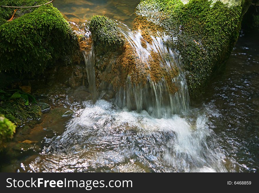 Micro Waterfall in wild forest on sunny day. Micro Waterfall in wild forest on sunny day...