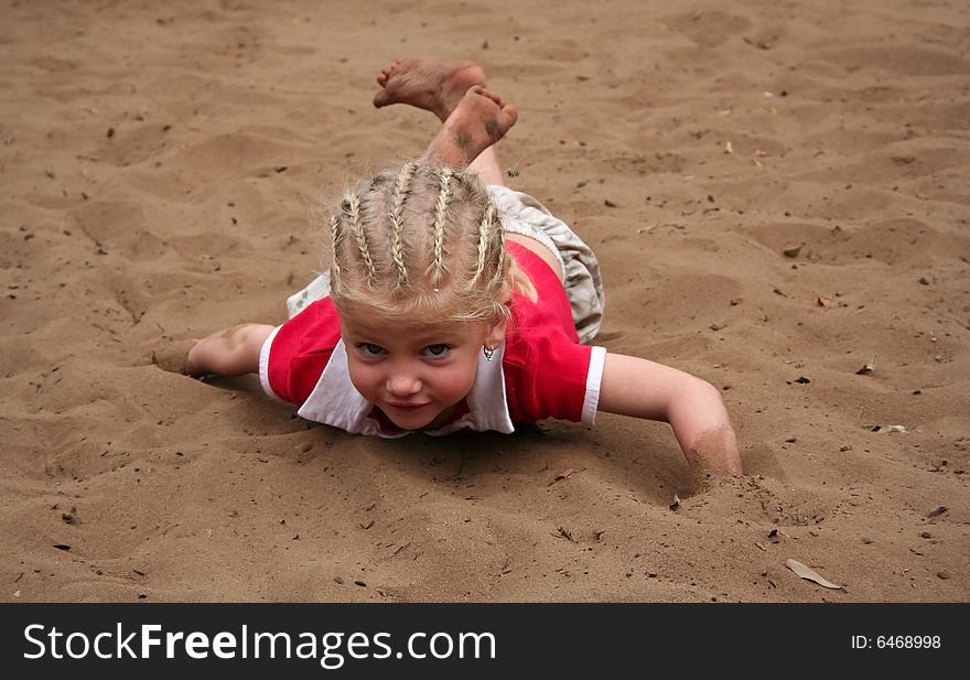 Little girl playing in sand dirtying her clothes and herself. Little girl playing in sand dirtying her clothes and herself