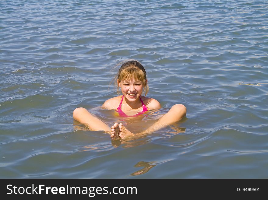 The cheerful girl swimming in the sea. The cheerful girl swimming in the sea