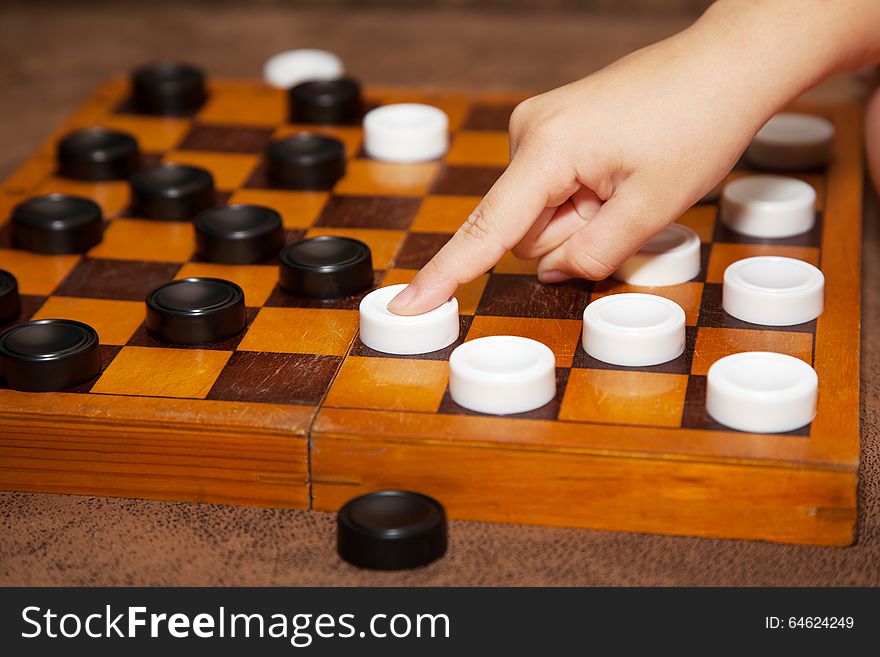 Child&#x27;s hand moves the piece to the chessboard
