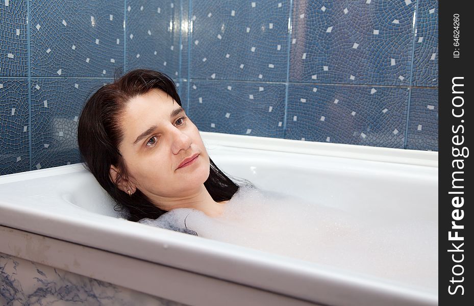 Young brunette woman lying in a bathtub closeup. Young brunette woman lying in a bathtub closeup