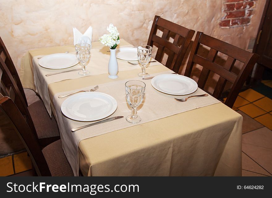 Wineglasses and plates on table in restaurant