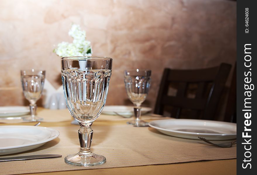 Wineglasses and plates on table in restaurant closeup