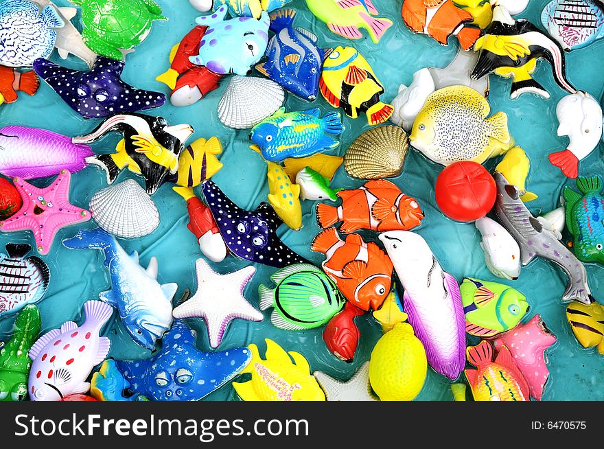 The colorful plastic toy sea animals floating in the water surface.