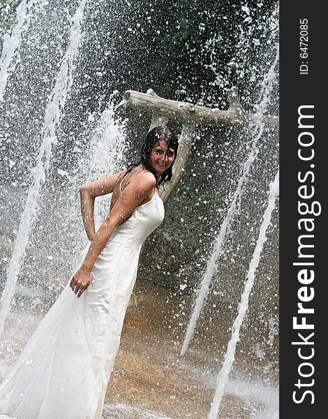 Bride playing under a water fountain. Bride playing under a water fountain.