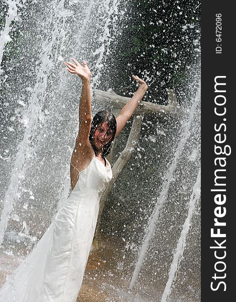 Bride playing under a water fountain. Bride playing under a water fountain.
