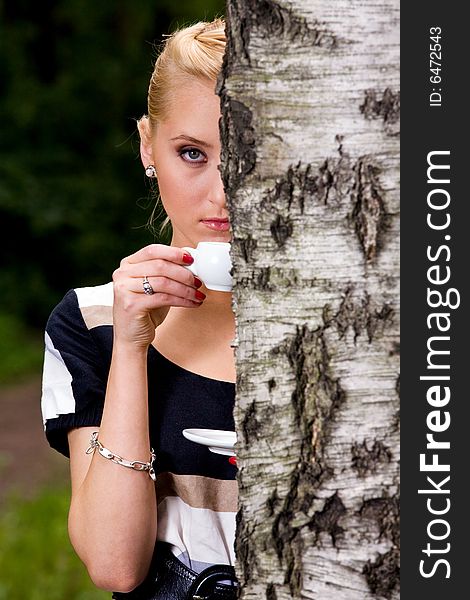 Blond lovely young woman drinking cup coffee outside. Blond lovely young woman drinking cup coffee outside