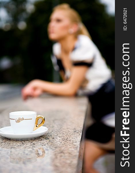 Blond lovely young woman drinking coffee outside. Blond lovely young woman drinking coffee outside