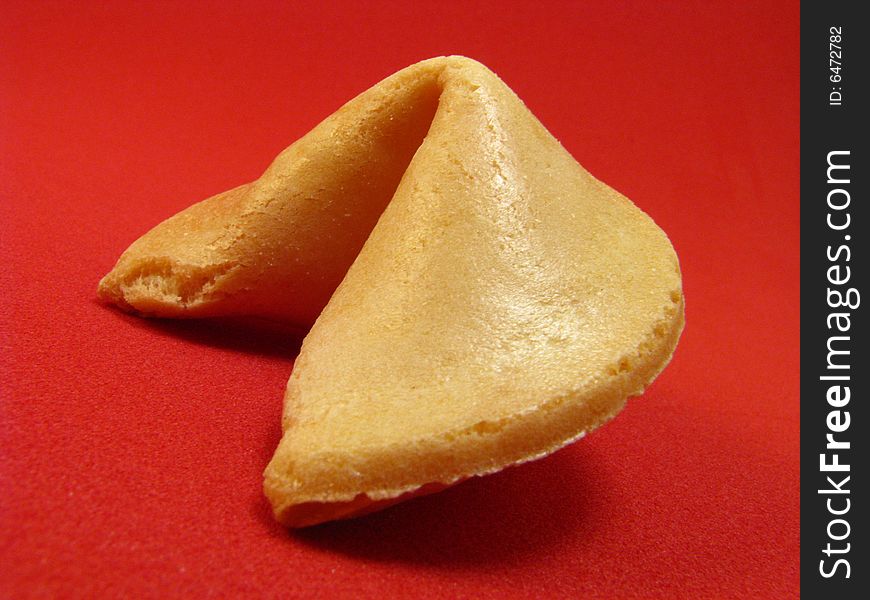 A traditional fortune cookie on a red background