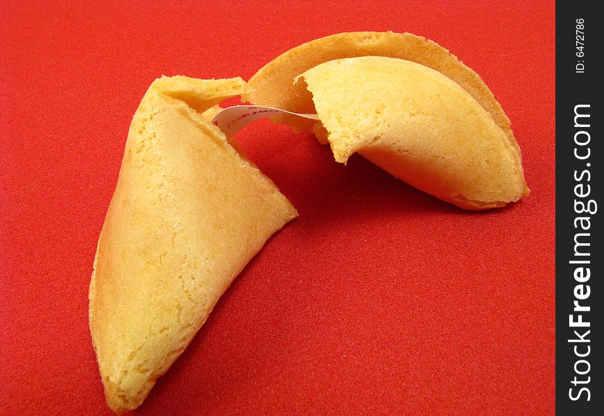 A traditional fortune cookie on a red background