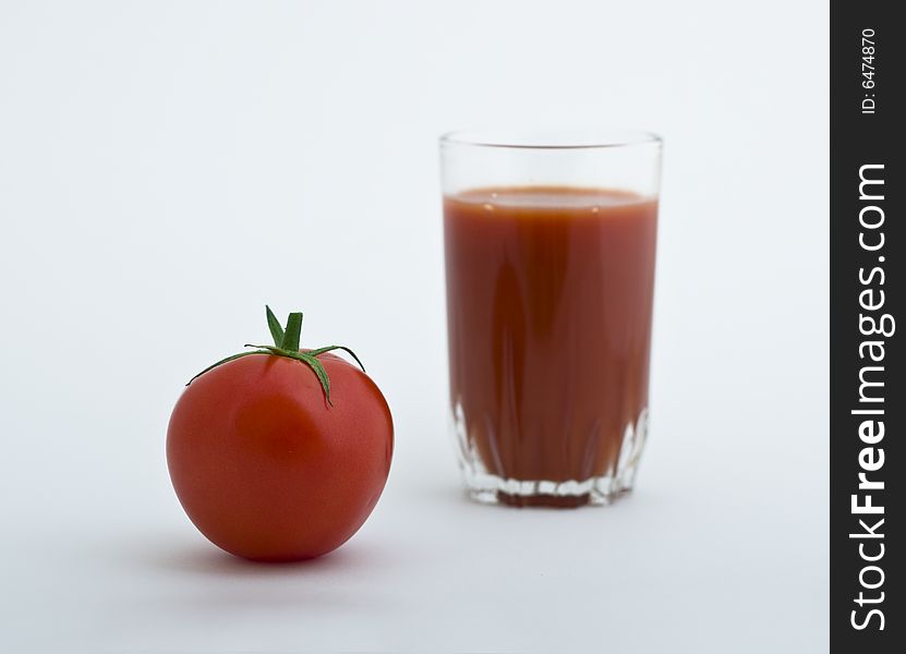 Fresh tomato and glass of juice on white background. Fresh tomato and glass of juice on white background