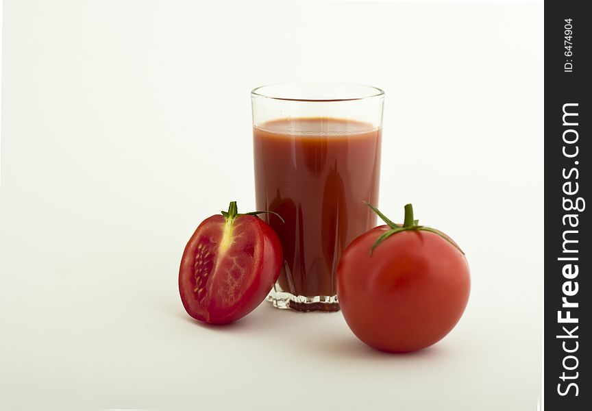 Fresh tomato and glass of juice on white background. Fresh tomato and glass of juice on white background