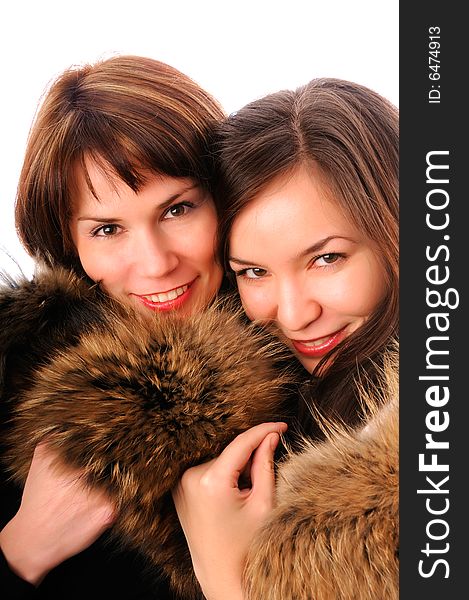 Two young beautiful woman in fur clothing isolated on white. Two young beautiful woman in fur clothing isolated on white