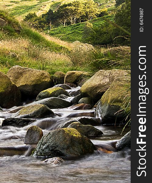 A stream flowing over some rocks. slow shutter speed showing some movement in the water. A stream flowing over some rocks. slow shutter speed showing some movement in the water.