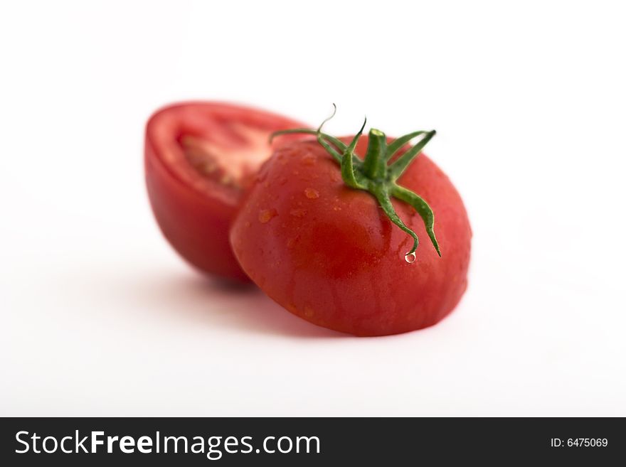 Fresh tomatoes with droplets  upon green background