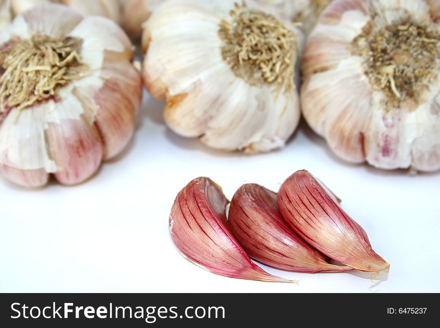 An image of many garlic pieces over white