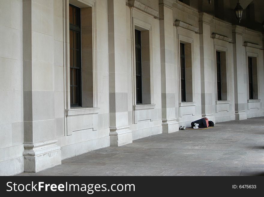 A homeless woman sleeping outside a government building. A homeless woman sleeping outside a government building