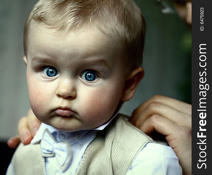 Little serious boy preparing for celebration