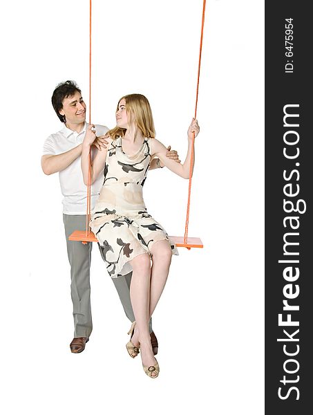 A man and a girl sitting on a swing. A man and a girl sitting on a swing