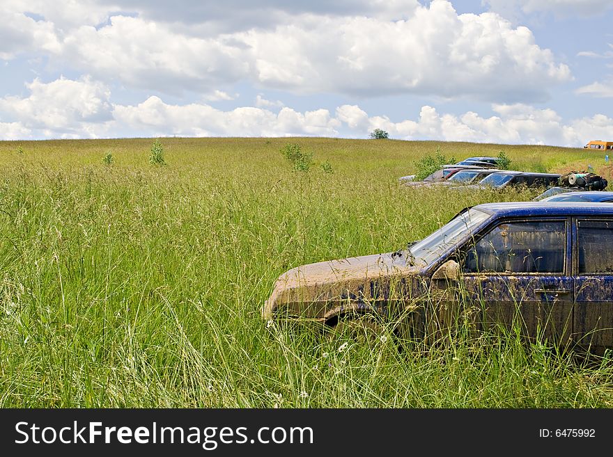 A dirty car standing in a green field. A dirty car standing in a green field