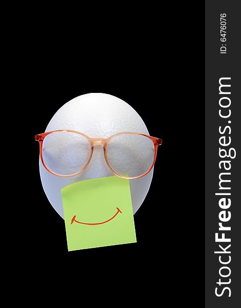 Smiling face made from ostrich egg and spectacles on black background. Smiling face made from ostrich egg and spectacles on black background