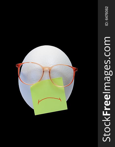 Sad face made from ostrich egg and spectacles on black background. Sad face made from ostrich egg and spectacles on black background