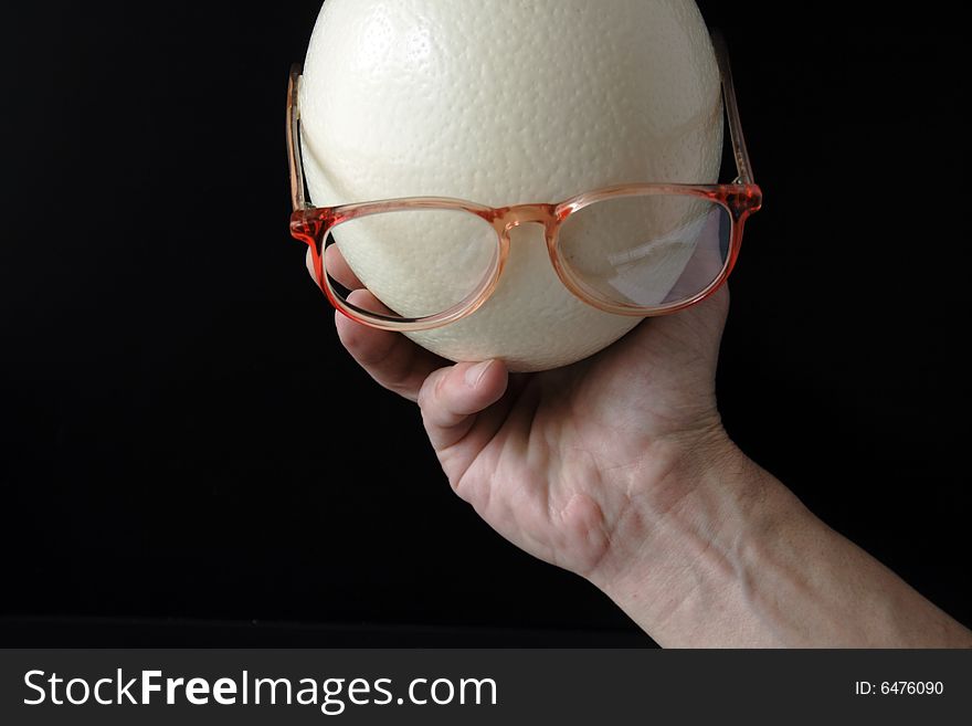 Male hand with head made from ostrich egg and spectacles. Male hand with head made from ostrich egg and spectacles