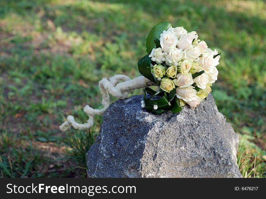The wedding bouquet with white roses on a stone. The wedding bouquet with white roses on a stone