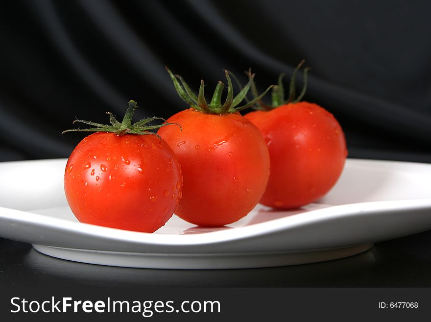 Fresh red tomatoes on white plate. Fresh red tomatoes on white plate