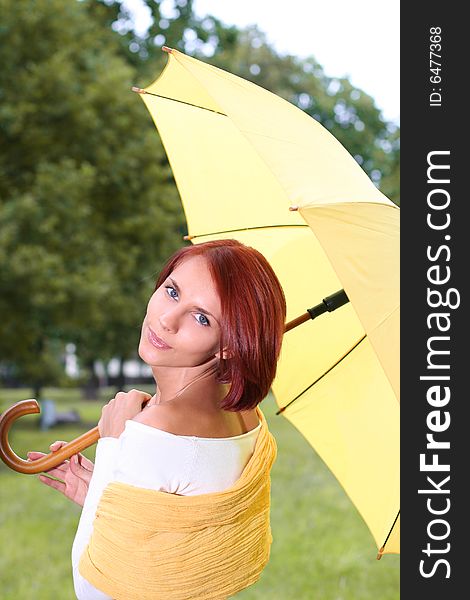 Beautiful young girl under yellow umbrella. Beautiful young girl under yellow umbrella