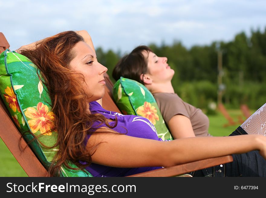 Two young girls relaxing outdoors. Two young girls relaxing outdoors