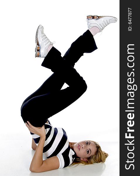 Female fitness trainer raising her legs on an isolated white background