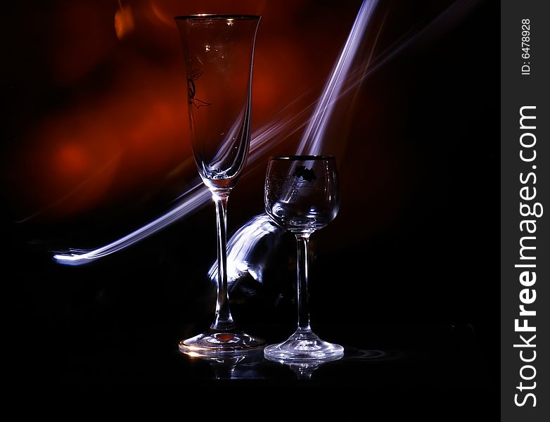 Two glasses in the black background with flash. Two glasses in the black background with flash