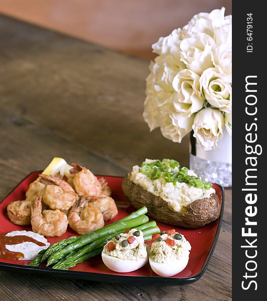 Dinner of shrimp, asparagus, deviled eggs, and potato. Dinner of shrimp, asparagus, deviled eggs, and potato