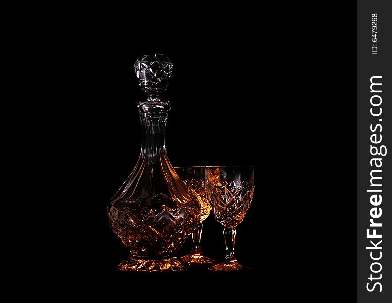 Decanter and two glasses in the black background with flash. Decanter and two glasses in the black background with flash