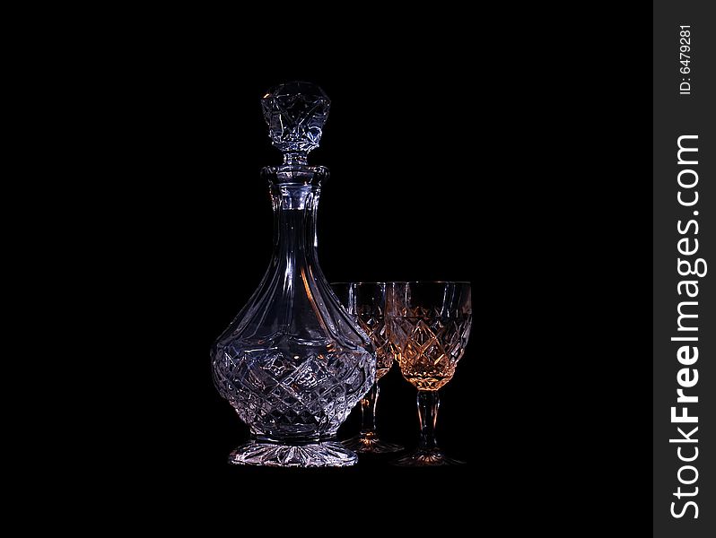 Decanter and two glasses in the black background with flash. Decanter and two glasses in the black background with flash