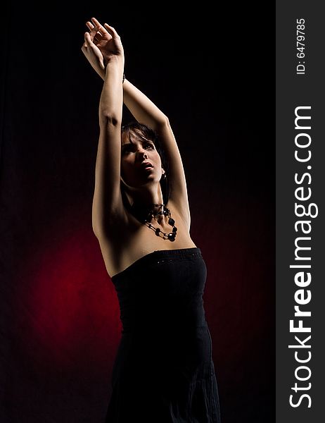 Beautiful model in black dress with hands reaching up. Beautiful model in black dress with hands reaching up