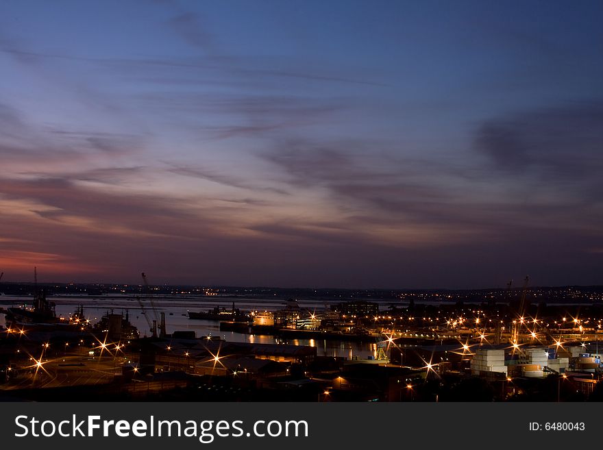 A view of Portsmouth Dock Yard at night with motor way light trails