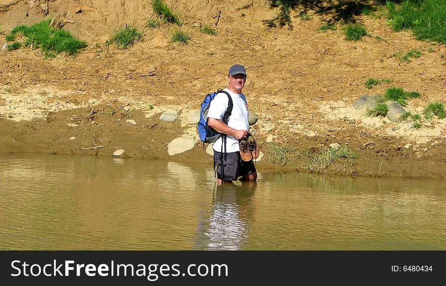 Hiker crosses a mountain river